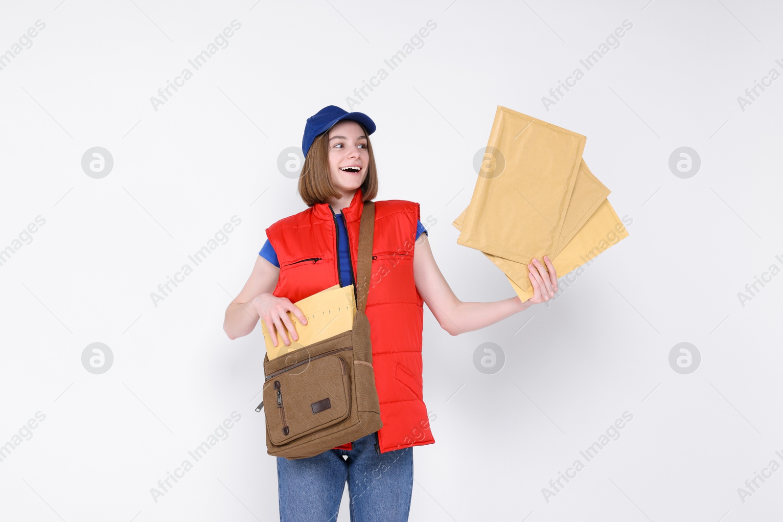 Photo of Happy postwoman with bag and envelopes on white background