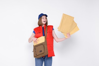 Photo of Happy postwoman with bag and envelopes on white background