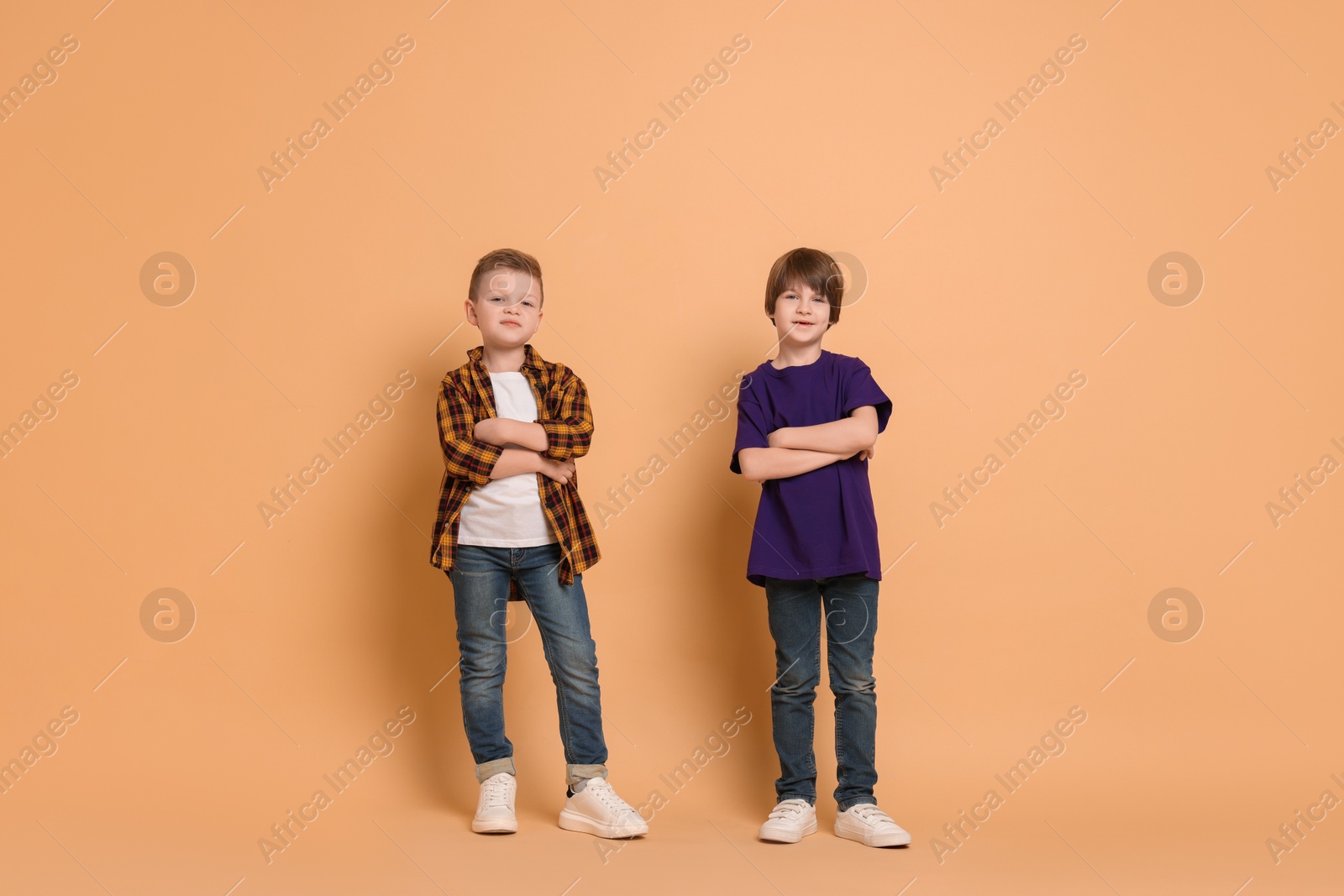 Photo of Full length portrait of cute brothers on beige background