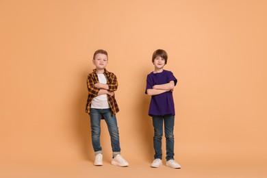 Photo of Full length portrait of cute brothers on beige background