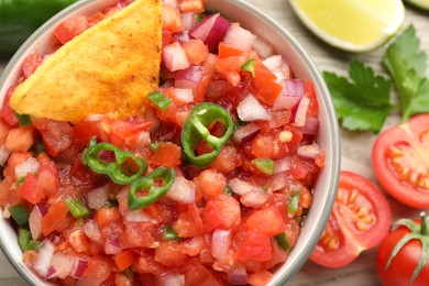 Delicious salsa and nacho in bowl on table, top view