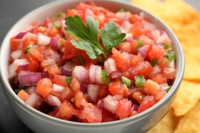 Delicious salsa in bowl on table, closeup