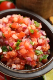 Delicious salsa in bowl on table, closeup