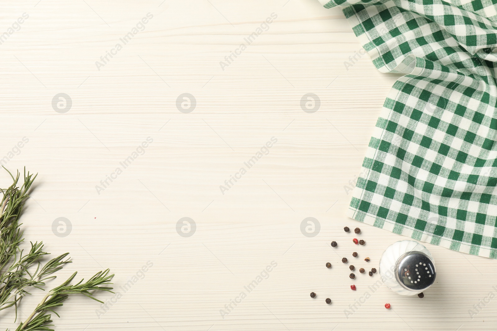 Photo of Checkered tablecloth, rosemary and spices on white wooden table, flat lay. Space for text