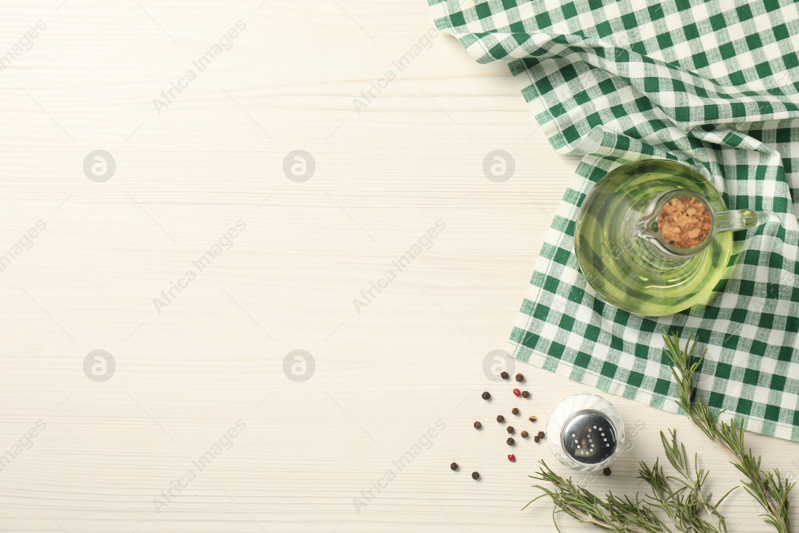 Photo of Checkered tablecloth, rosemary, oil and spices on white wooden table, flat lay. Space for text