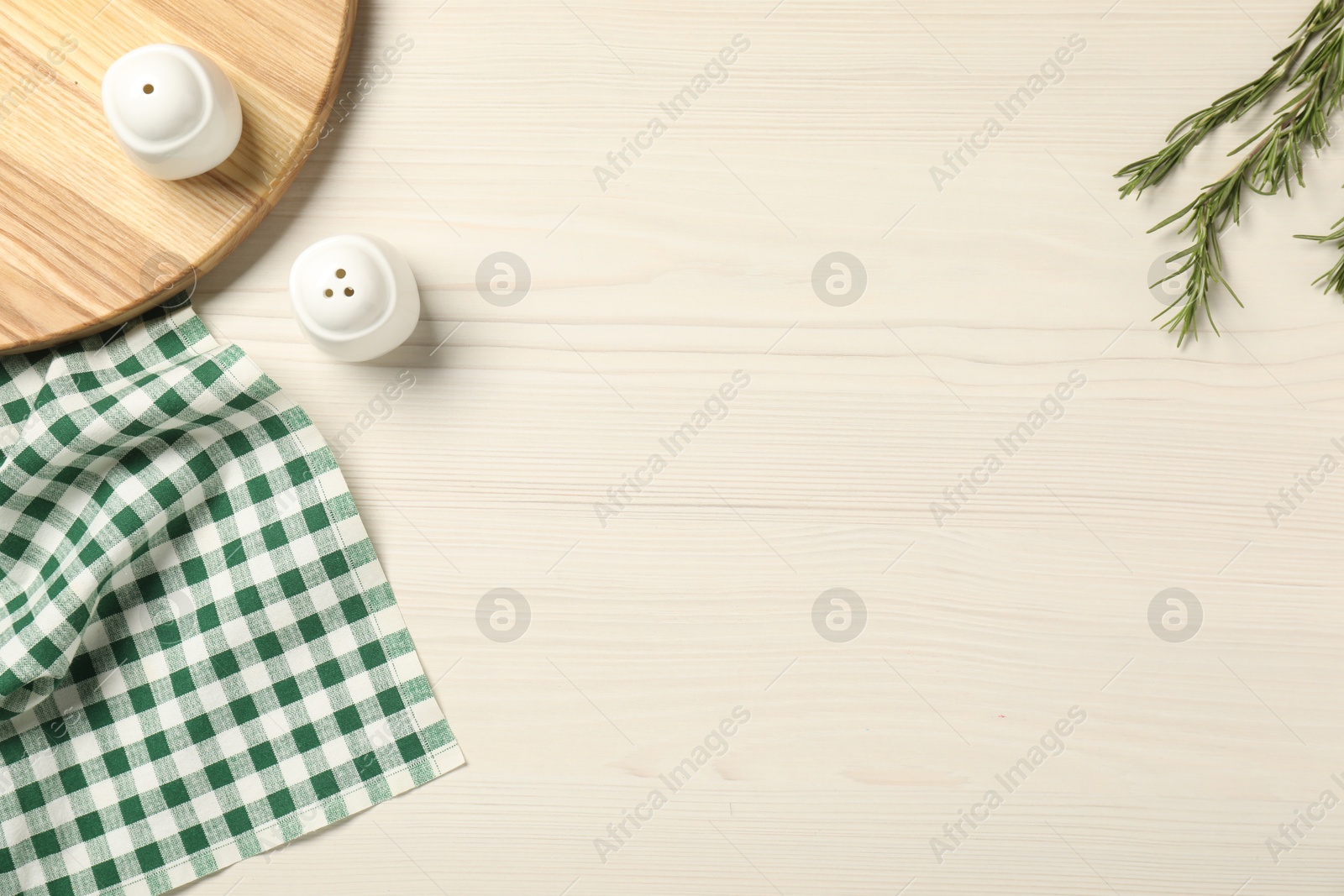 Photo of Checkered tablecloth, rosemary and spices on white wooden table, flat lay. Space for text