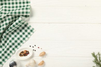 Photo of Checkered tablecloth and spices on white wooden table, flat lay. Space for text