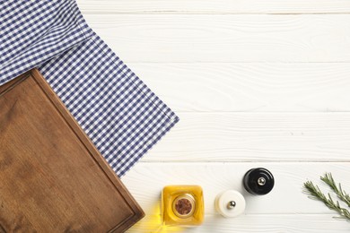 Photo of Checkered tablecloth, cutting board, oil and spices on white wooden table, flat lay. Space for text