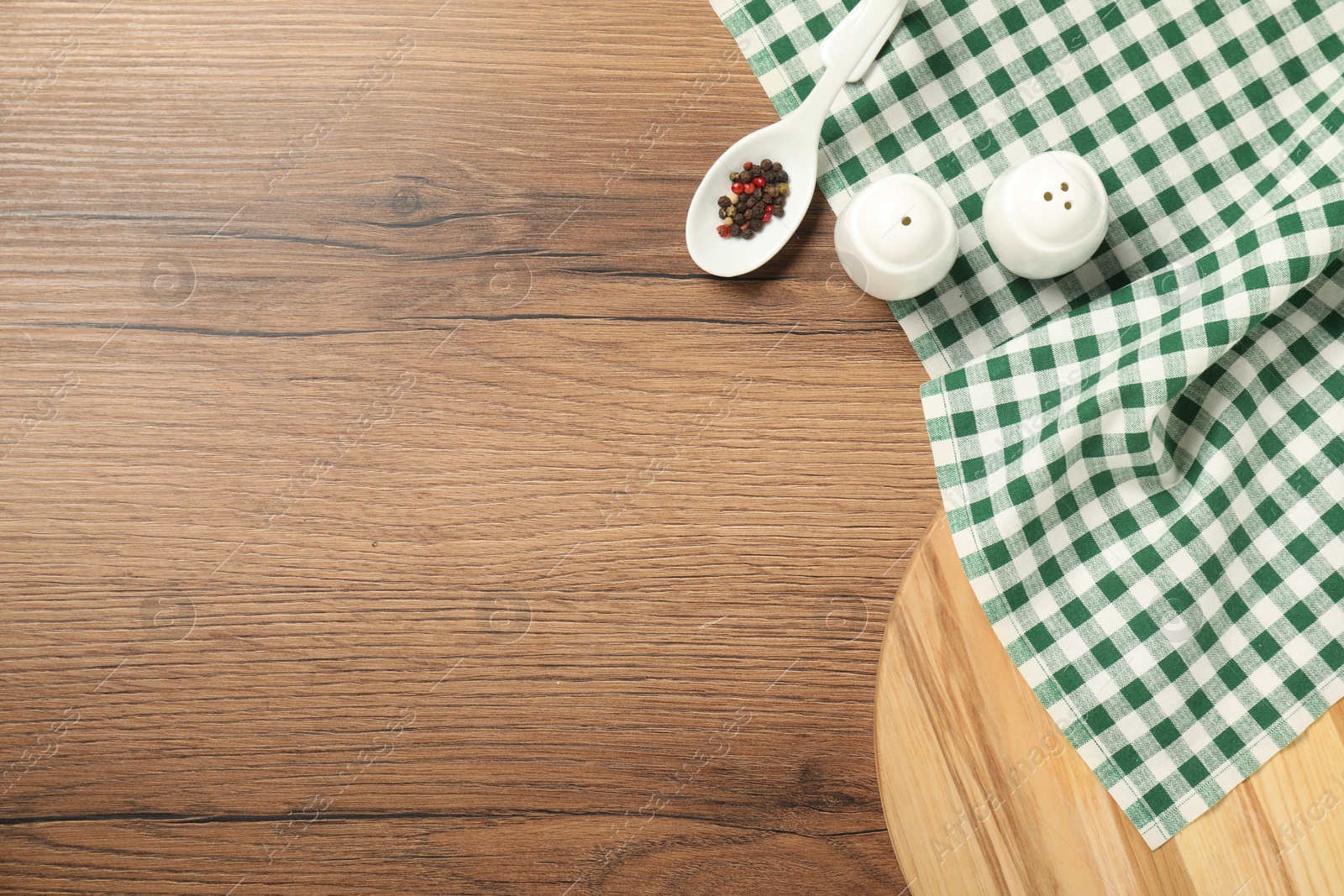 Photo of Checkered tablecloth and spices on wooden table, flat lay. Space for text