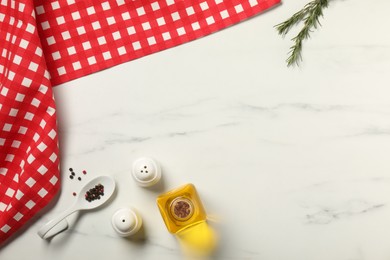 Photo of Checkered tablecloth, oil and spices on white marble table, flat lay. Space for text