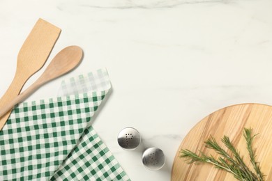 Photo of Checkered tablecloth, cooking utensils and spices on white marble table, flat lay. Space for text