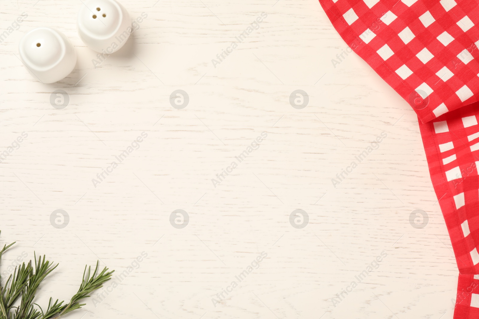 Photo of Checkered tablecloth and spices on white wooden table, flat lay. Space for text