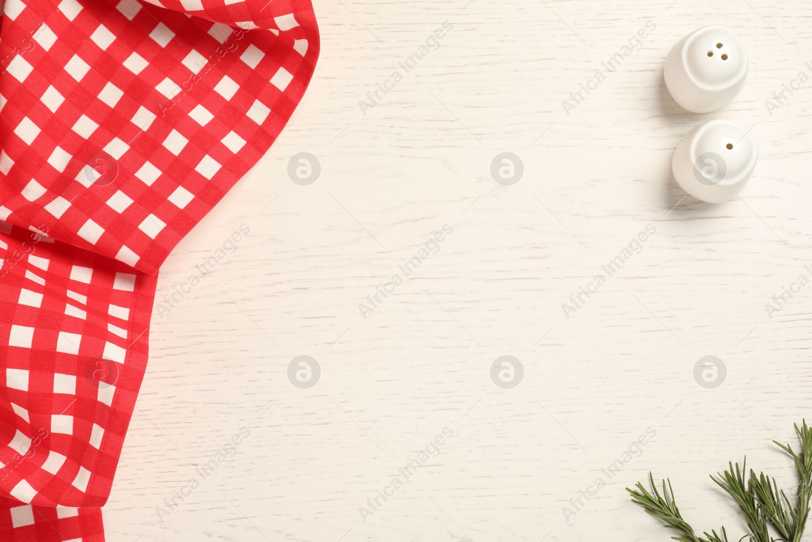 Photo of Checkered tablecloth and spices on white wooden table, flat lay. Space for text