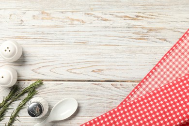 Photo of Checkered tablecloth, rosemary and spices on white wooden table, flat lay. Space for text