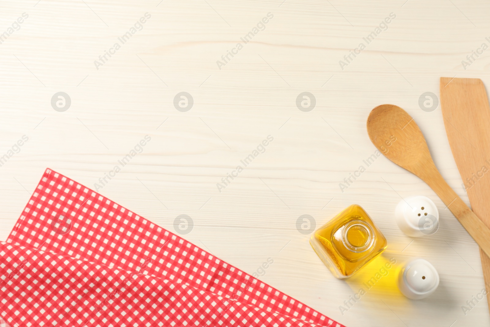 Photo of Checkered tablecloth, cooking utensils, oil and spices on white wooden table, flat lay. Space for text