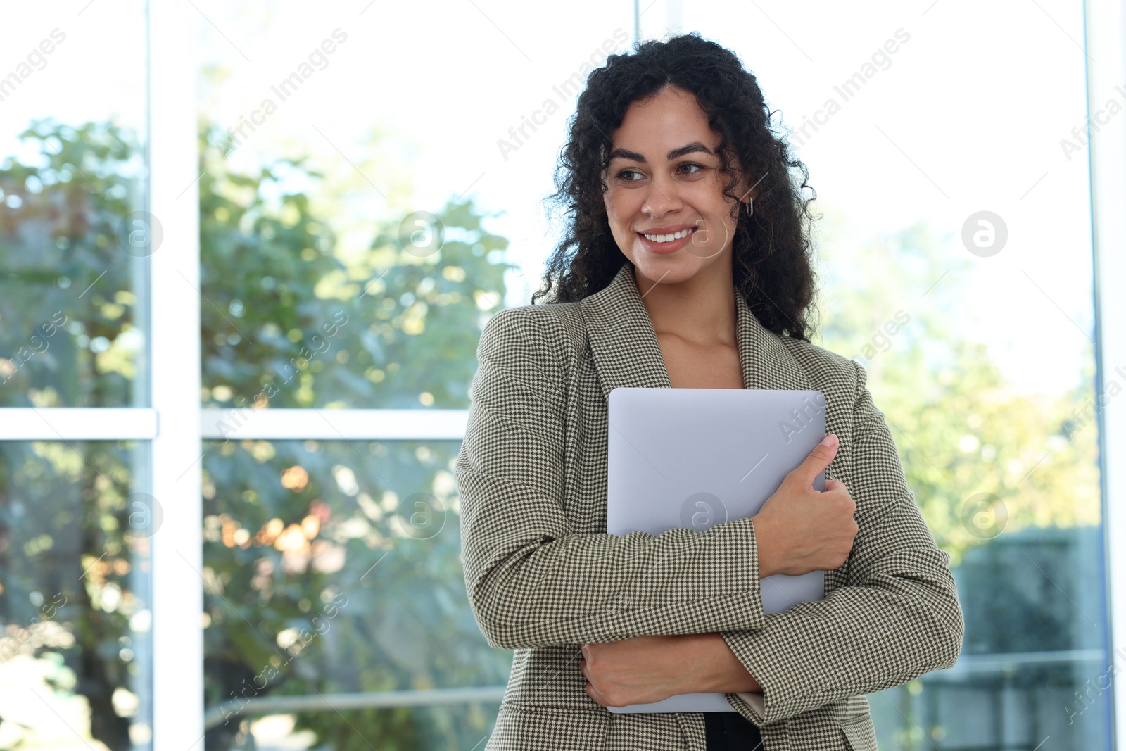 Photo of Portrait of young woman with laptop wearing stylish suit indoors