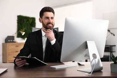 Photo of Man working with document at table in office