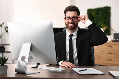 Photo of Man with glasses working at table in office