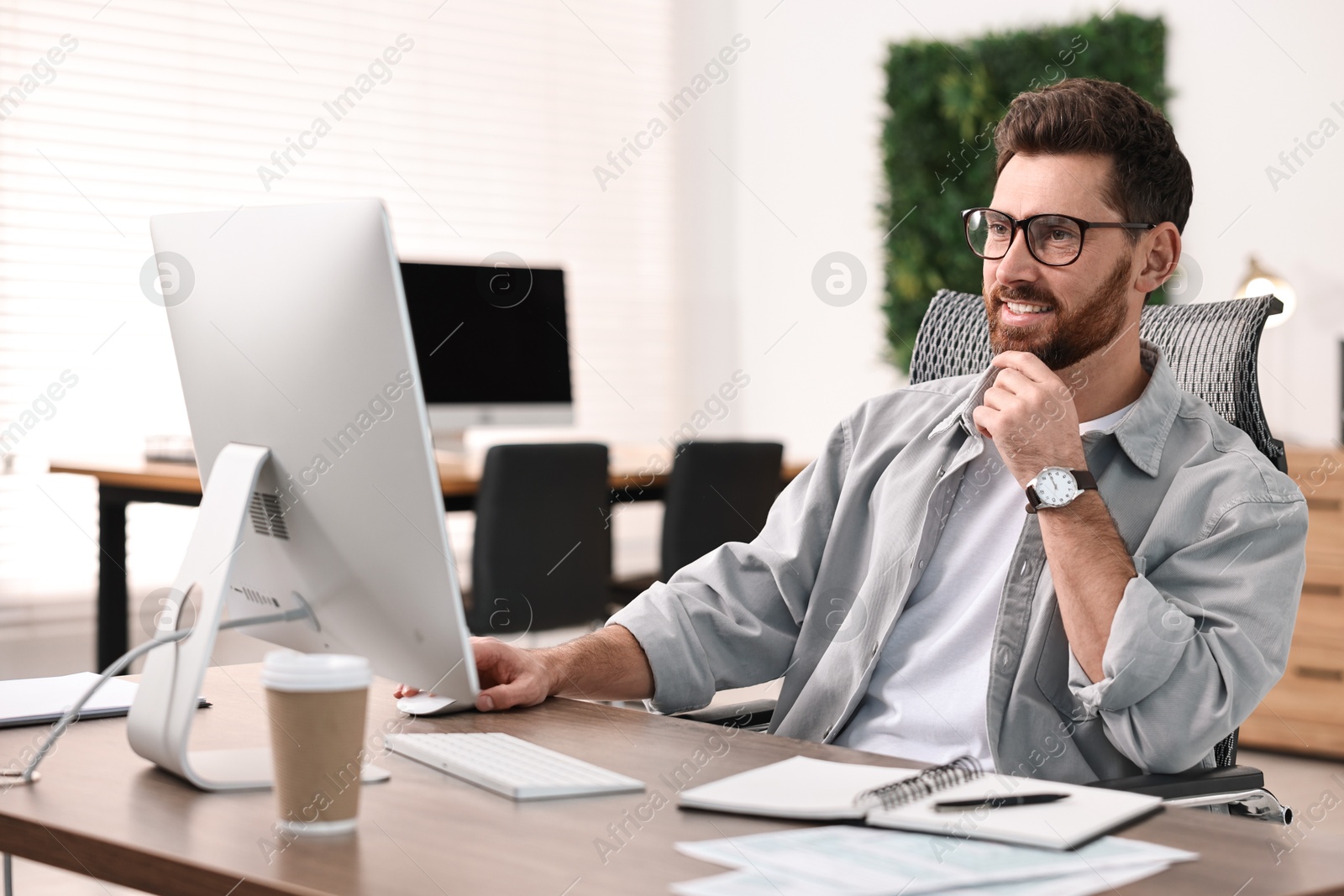 Photo of Man working on computer at table in office