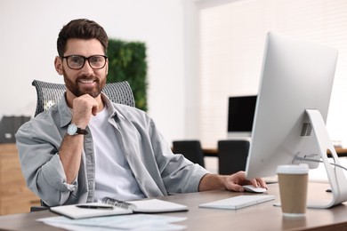 Photo of Man working on computer at table in office