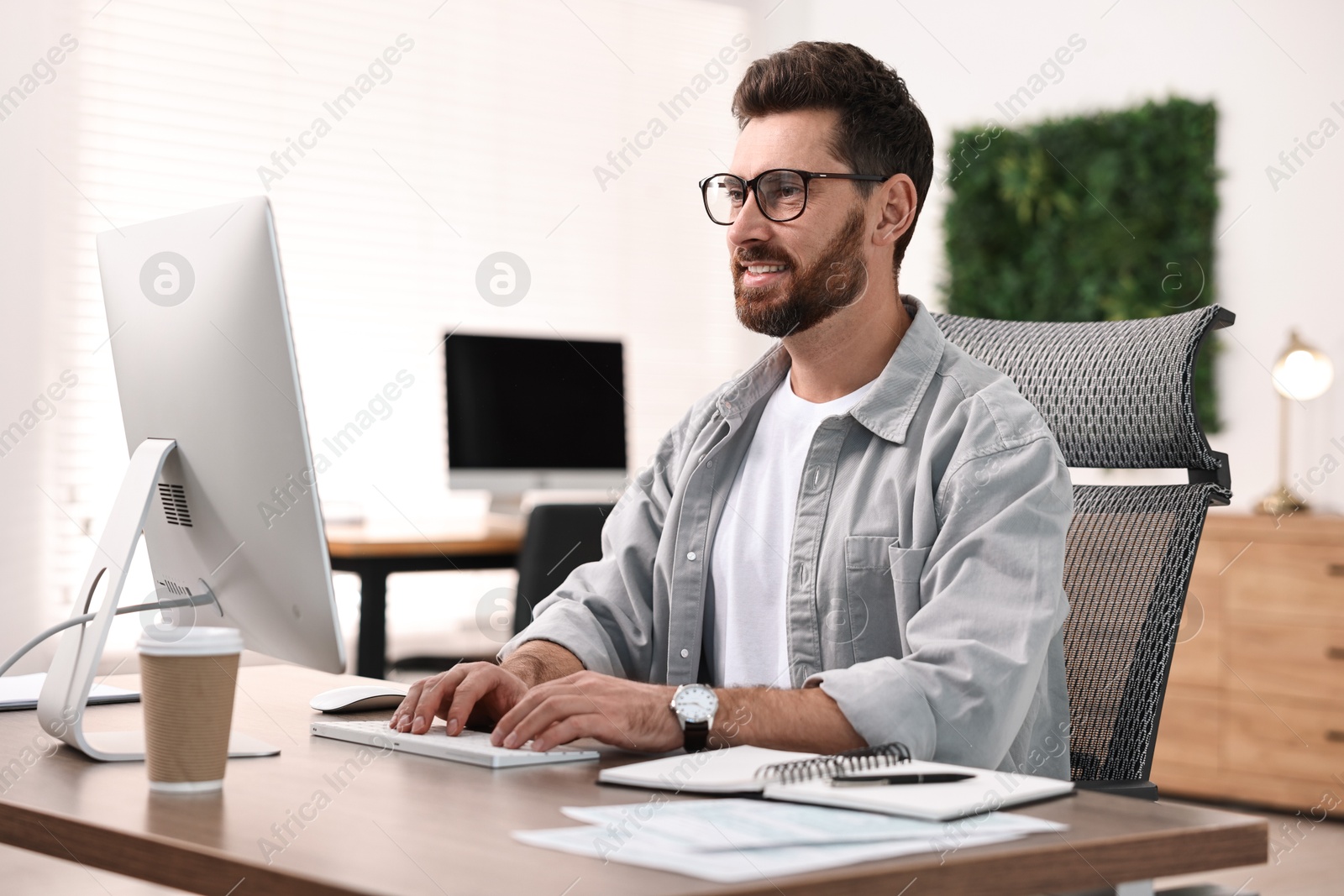 Photo of Man working on computer at table in office