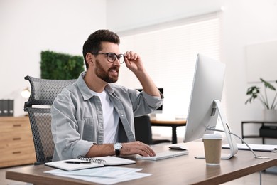 Photo of Man working on computer at table in office