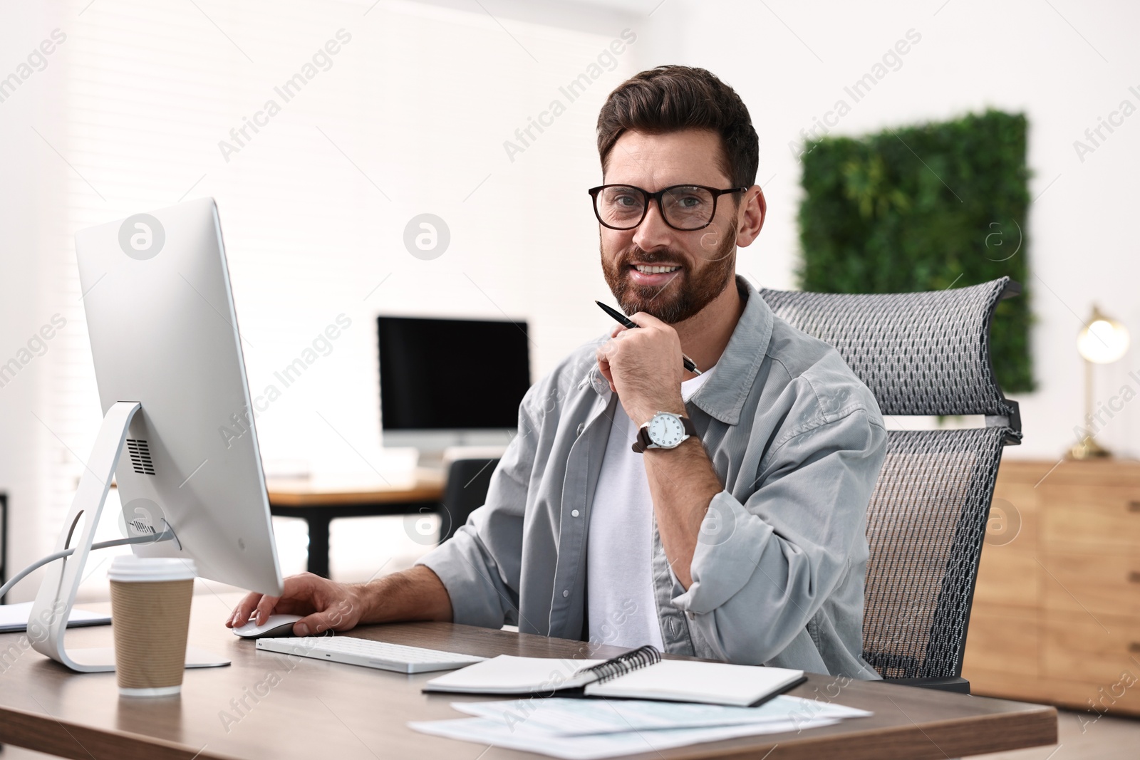 Photo of Man working on computer at table in office