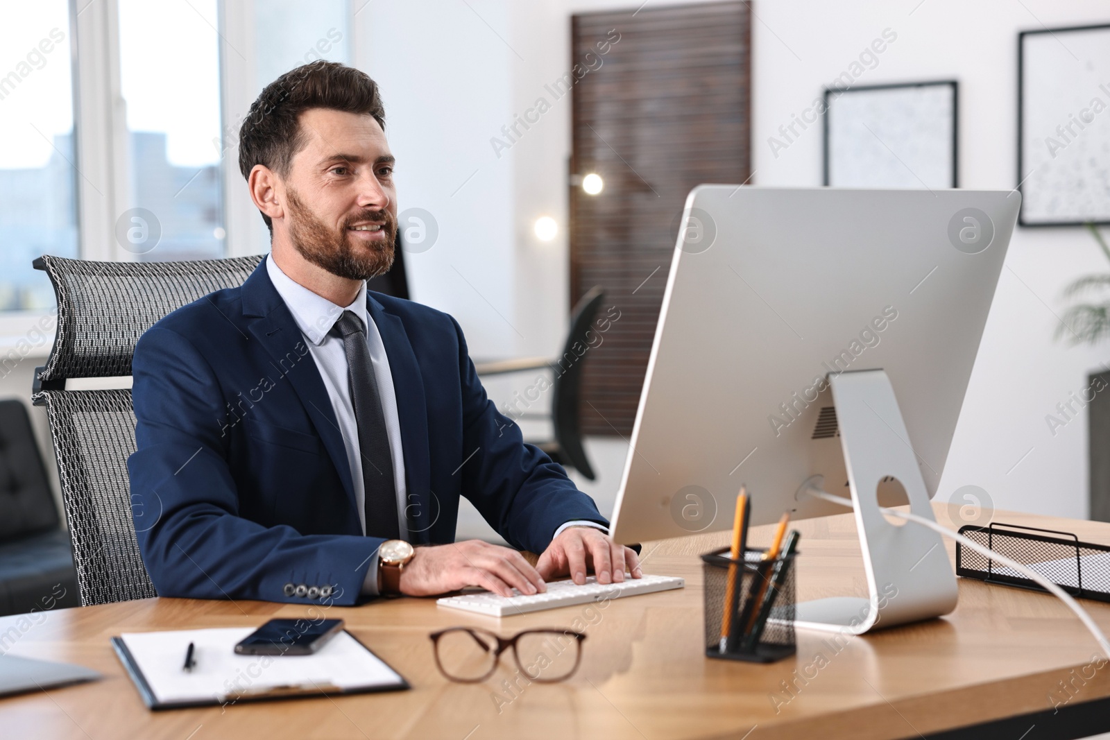 Photo of Man working on computer at table in office