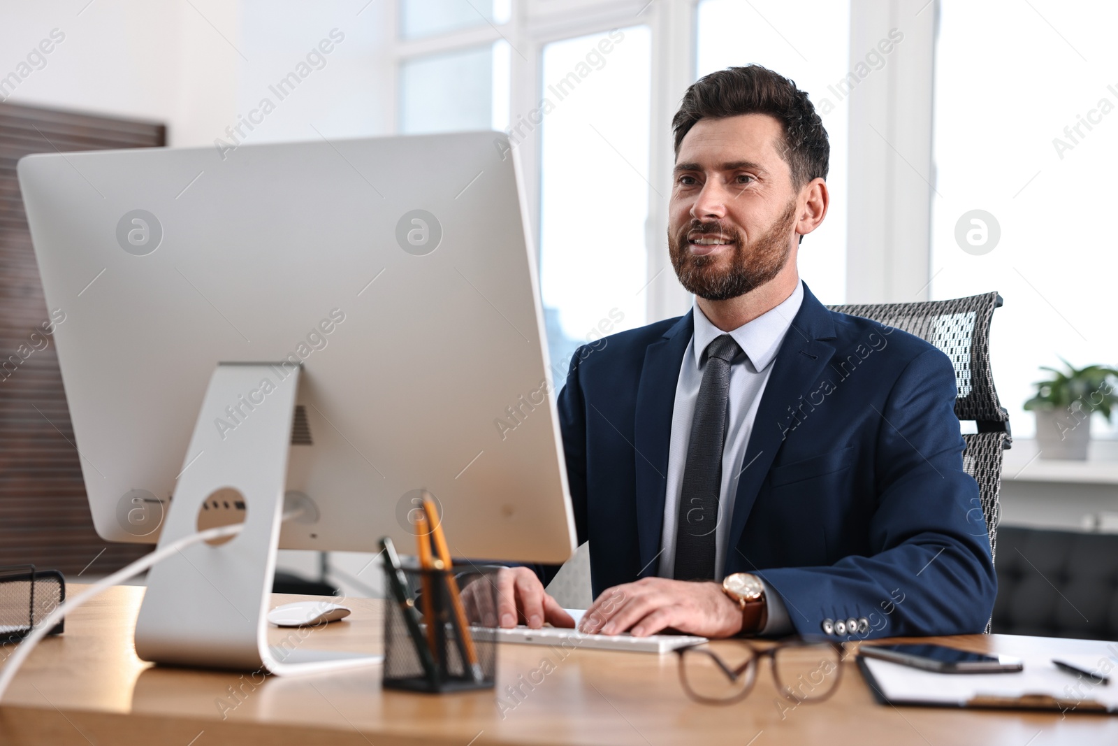 Photo of Man working on computer at table in office