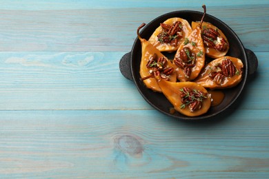 Photo of Delicious pears with caramel sauce, pecan nuts and thyme on light blue wooden table, top view. Space for text