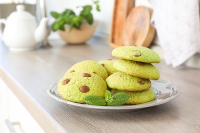 Photo of Delicious mint chocolate chip cookies on wooden table