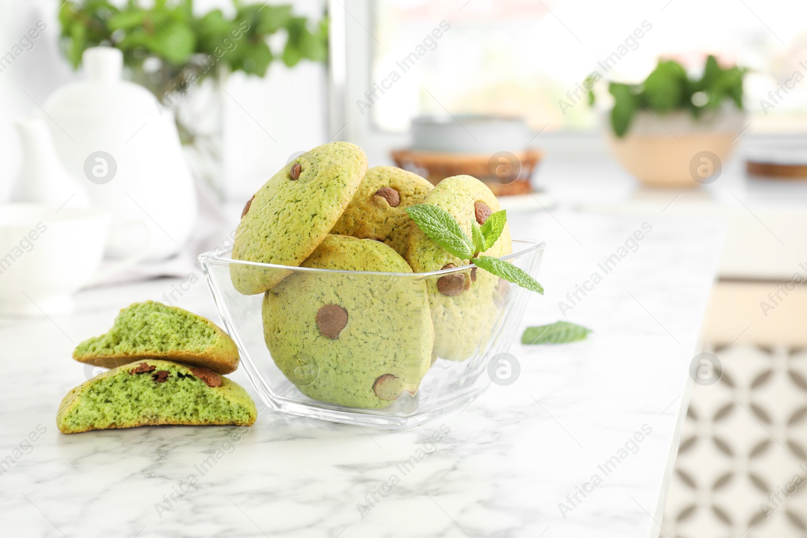 Photo of Delicious mint chocolate chip cookies on white marble table