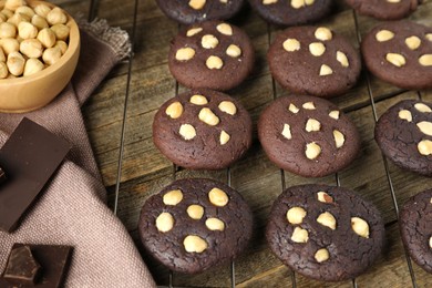 Photo of Tasty chocolate cookies with hazelnuts on wooden table, closeup