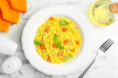 Photo of Delicious pumpkin risotto served on white marble table, flat lay