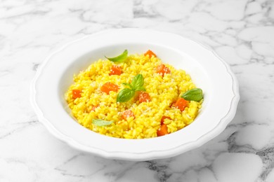 Photo of Delicious pumpkin risotto on white marble table, closeup