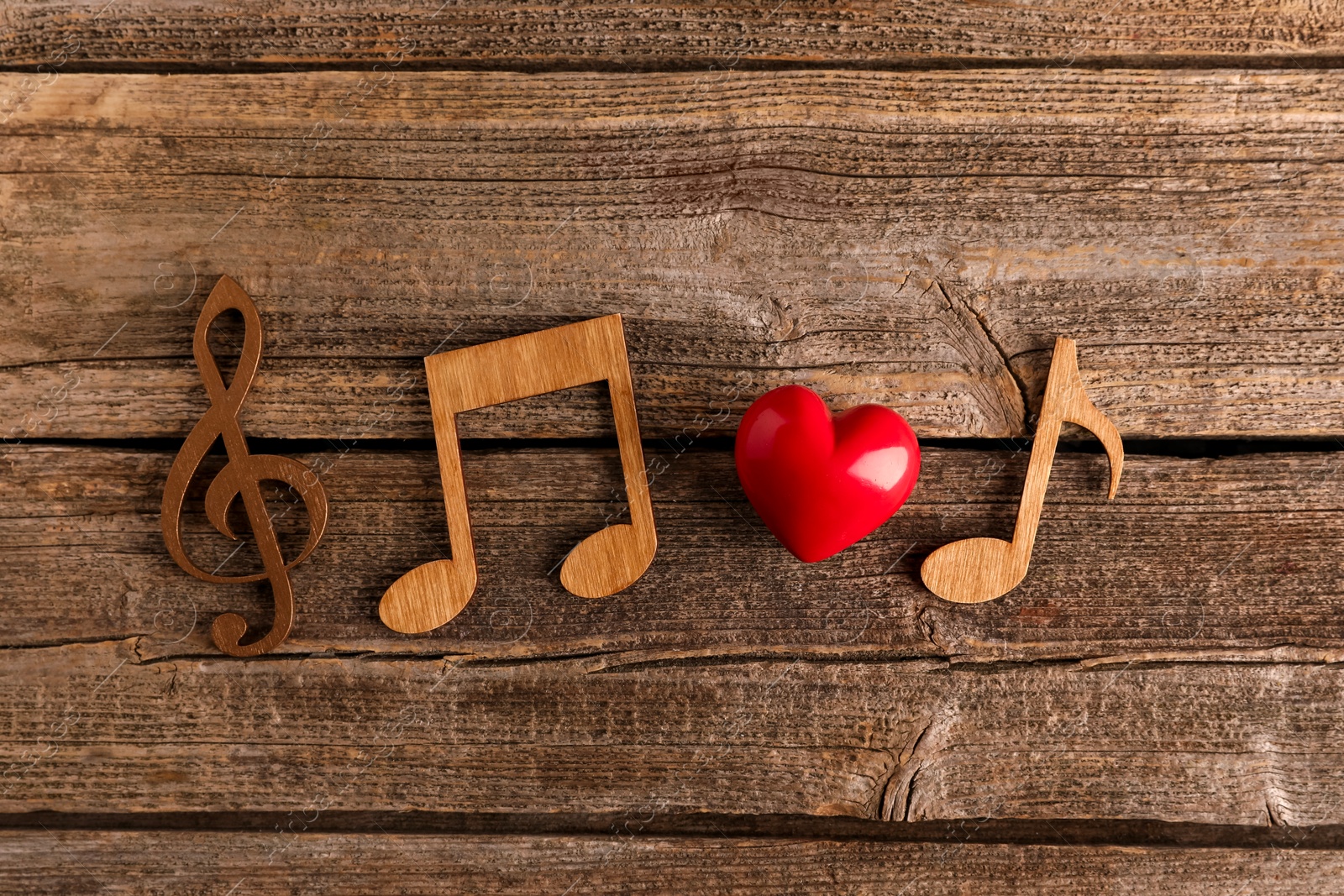 Photo of Red heart figure and notes on wooden table, flat lay