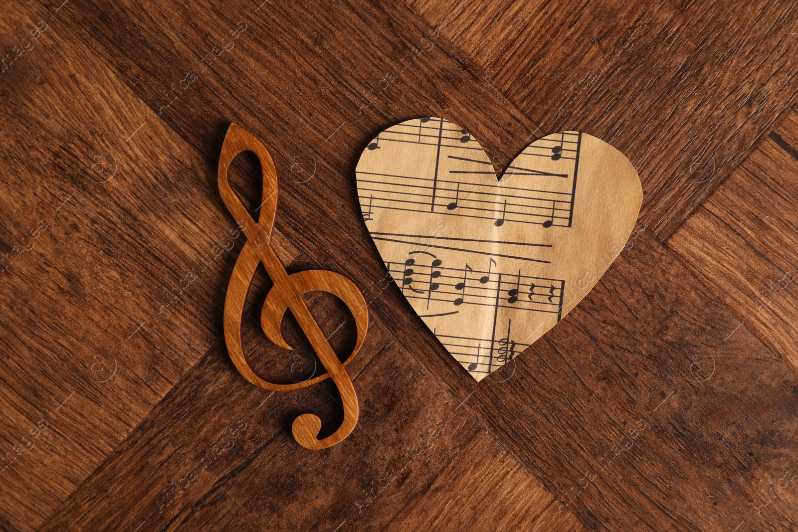 Photo of Paper heart and clef note on wooden table, top view