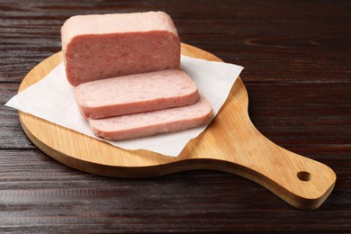 Photo of Tasty canned meat on wooden table, closeup