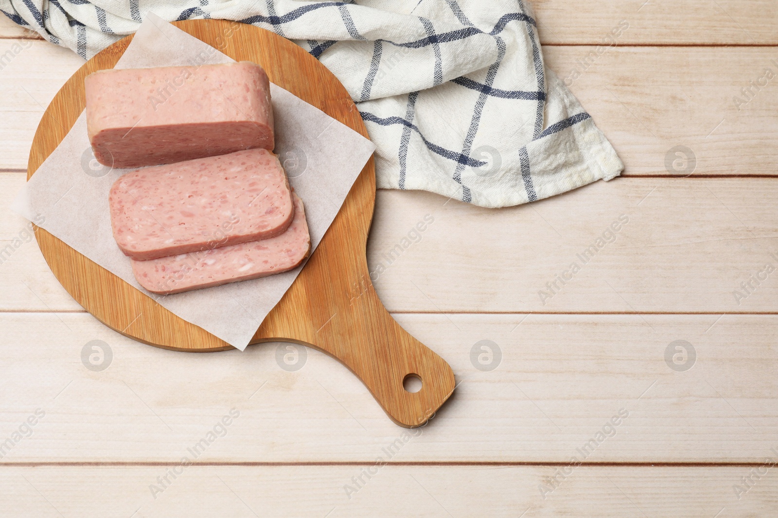 Photo of Tasty canned meat on wooden table, top view. Space for text