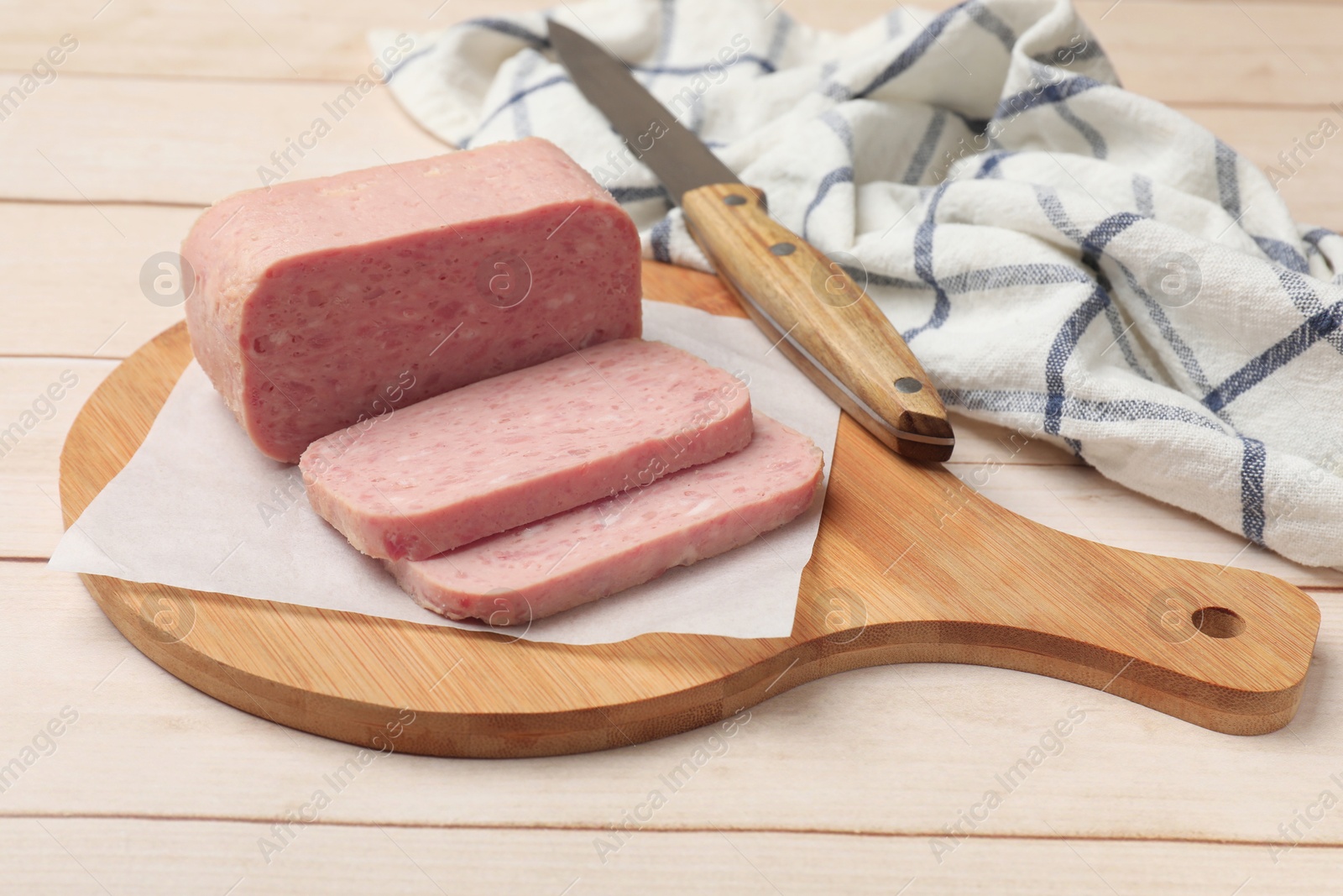 Photo of Tasty canned meat and knife on wooden table