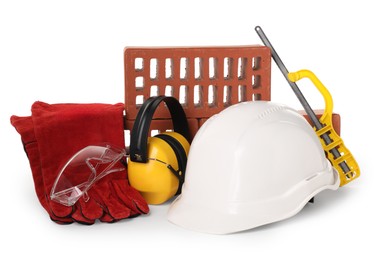 Photo of Safety equipment, red bricks and small hand saw isolated on white. Construction tools and building material