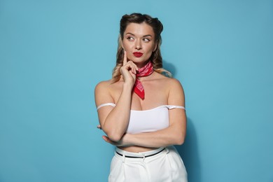 Photo of Attractive pin-up woman on light blue background