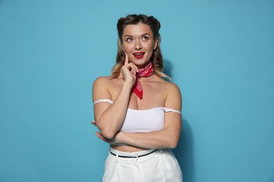 Photo of Attractive pin-up woman on light blue background