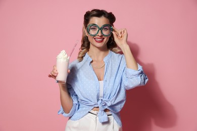 Photo of Happy pin-up woman with milk shake on pink background