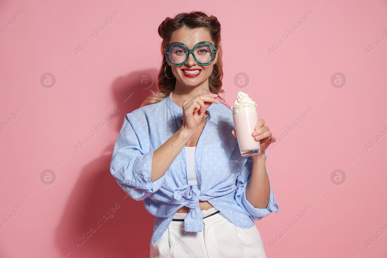 Photo of Happy pin-up woman with milk shake on pink background