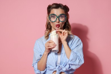 Photo of Attractive pin-up woman with milk shake on pink background