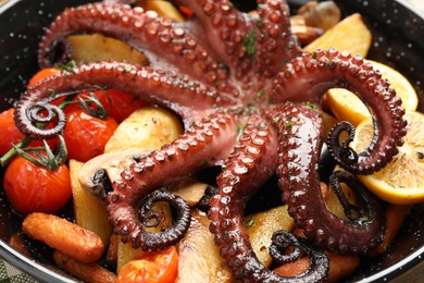 Photo of Fried octopus with lemon and vegetables in pan, closeup