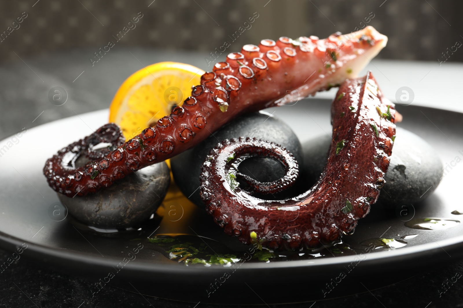 Photo of Fried octopus with herb sauce and lemon served on table, closeup