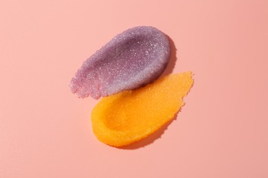 Photo of Smears of body scrubs on light pink background, top view