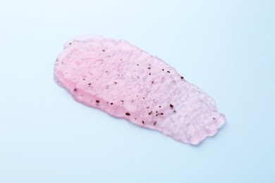 Photo of Smear of body scrub on light blue background, closeup